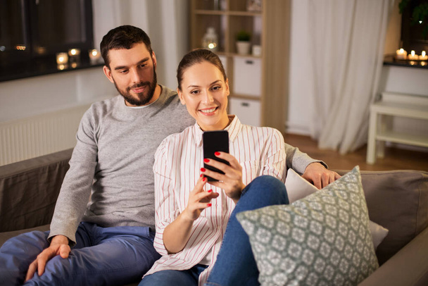 happy couple with smartphone taking selfie at home - Foto, Imagem