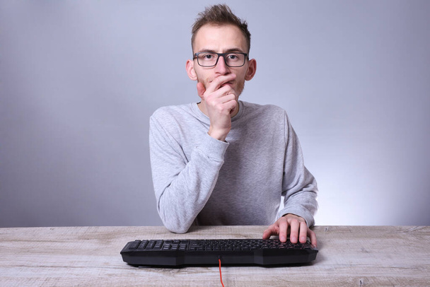 Divertido empollón joven hombre de negocios, hombre que trabaja en computer.Typing el programador de teclado en gafas delante de la computadora. - Foto, imagen