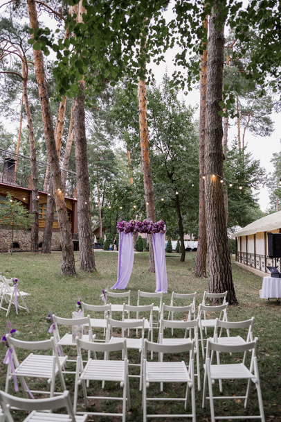 arch for a wedding ceremony with purple flowers - Foto, afbeelding