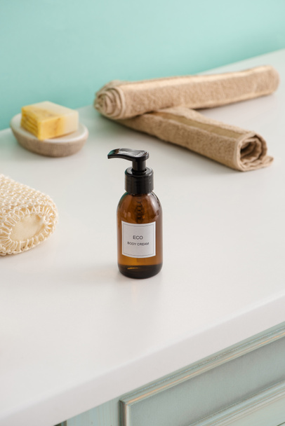 Enfoque selectivo de objetos de higiene con botella de crema corporal ecológica en el baño, concepto de cero residuos
 - Foto, imagen