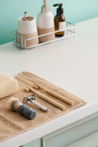 Productos cosméticos en estante con objetos de higiene en la toalla en el baño, concepto de cero residuos
 - Foto, imagen