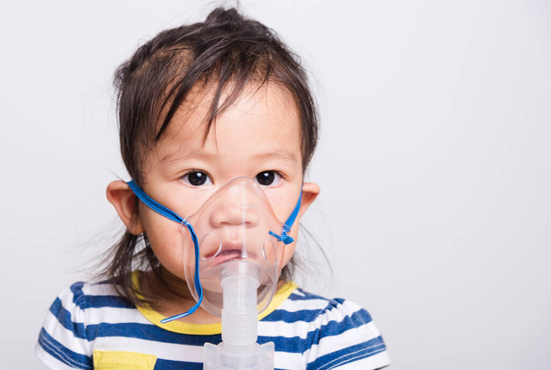 Closeup Asian face, Little baby girl sick her using steam inhaler nebulizer mask inhalation oneself on white background with copy space, health medical care - Фото, зображення