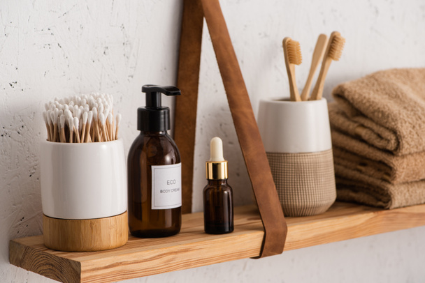 Selective focus of hygiene and cosmetic products with towels on shelf in bathroom, zero waste concept - Photo, Image