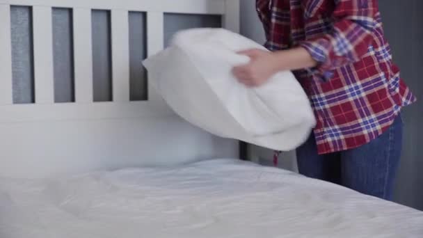 Kobieta sprzątanie jej łóżko w sypialni, Piękna kobieta ustawić i pościelić łóżko, układając jej poduszki i poduszki starannie - Materiał filmowy, wideo