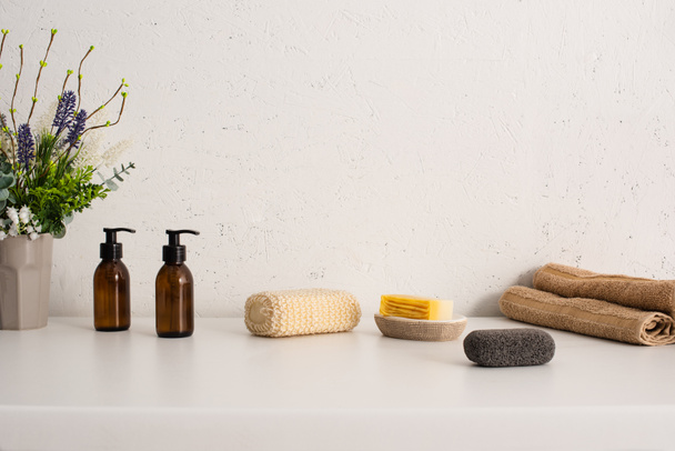Maceta, toallas, productos de higiene y cosméticos en el baño, concepto de cero residuos
 - Foto, imagen