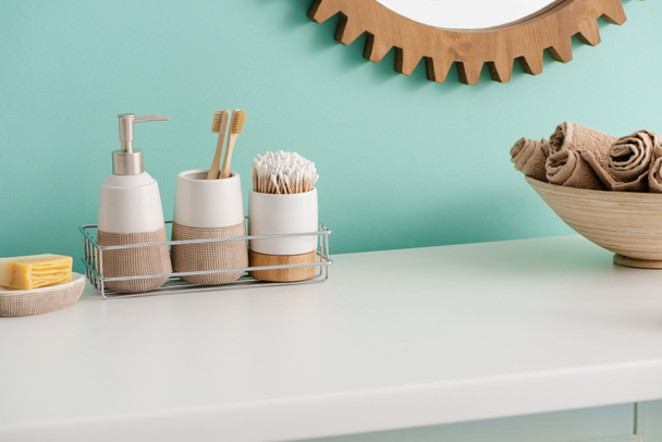 Dish with soap, shelf with hygiene objects, bowl with towels and mirror in bathroom, zero waste concept - Photo, Image