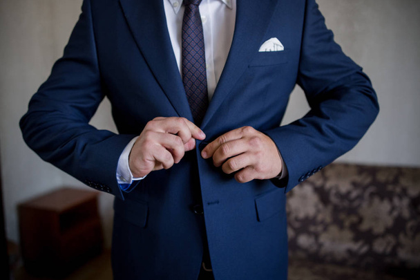 man fastens suit jacket - Photo, image
