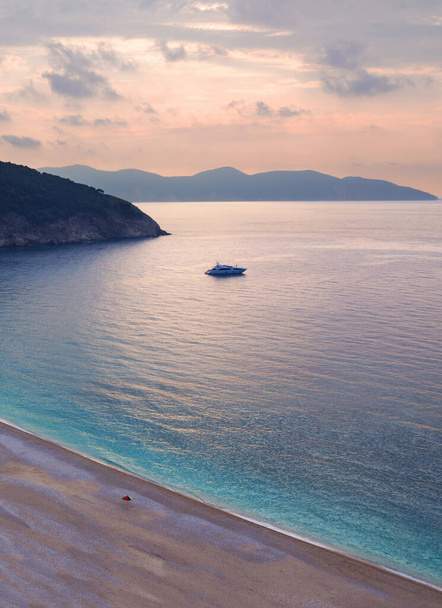 Пляж с бирюзовой водой на закате на острове Кефалония в Ионическом море в Греции
 - Фото, изображение