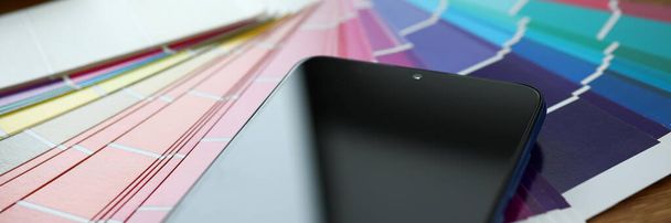 Screen of moderni älypuhelin makaa värikäs fantail
 - Valokuva, kuva