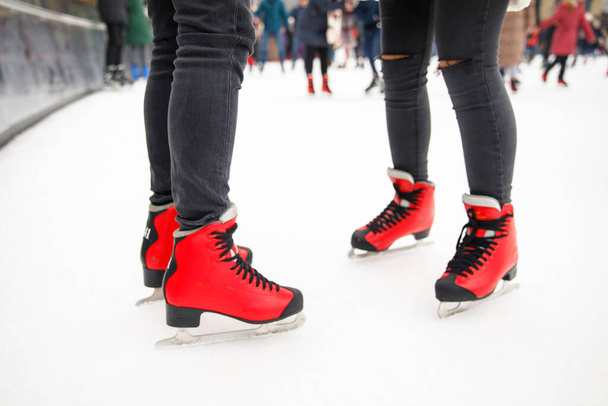 close up of boy and girl legs in skates on ice rink background - Fotó, kép