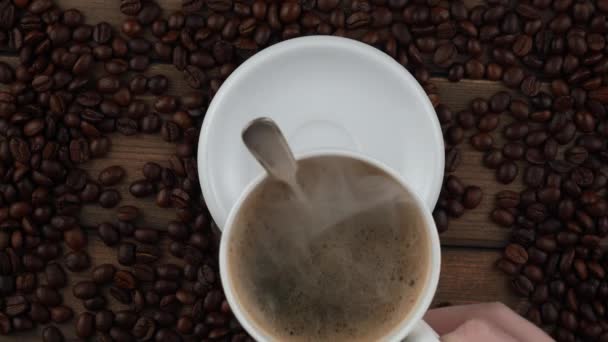 Ζεστός καφές σε ένα φλιτζάνι με ατμό σε ένα παλιό φόντο. - Πλάνα, βίντεο
