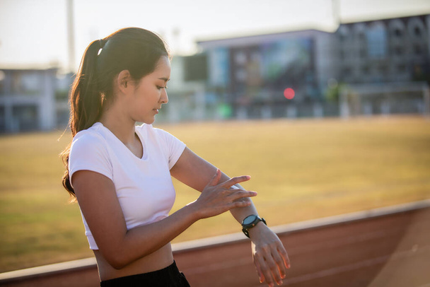 Asian Woman applying and spraying sunscreen cream on skin before run. Sports and healthy concept - Photo, Image