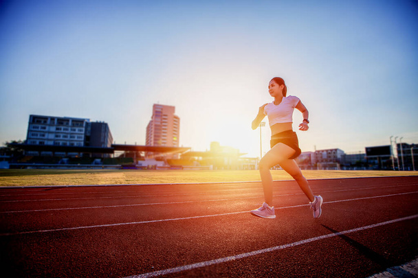 Asiatique jeune femme fitness coureur courir sur la piste du stade  - Photo, image
