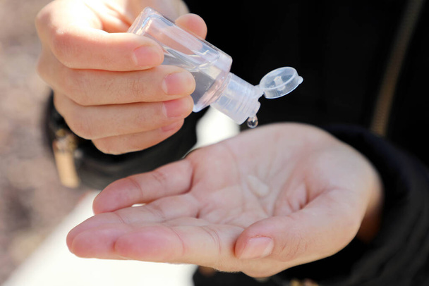 COVID-19 Gros plan sur les mains des femmes utilisant un distributeur de gel désinfectant pour les mains, contre le nouveau coronavirus (2019-nCoV) ou le coronavirus Wuhan dans la rue de la ville. Concept d'antiseptique, d'hygiène et de santé
. - Photo, image