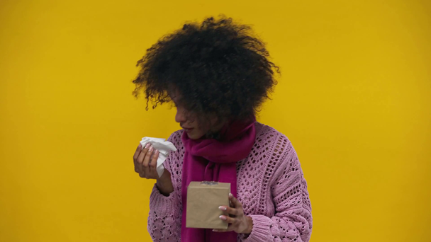 chore afrykańskie amerykańskie dziewczyna kichanie izolowane na żółty  - Materiał filmowy, wideo
