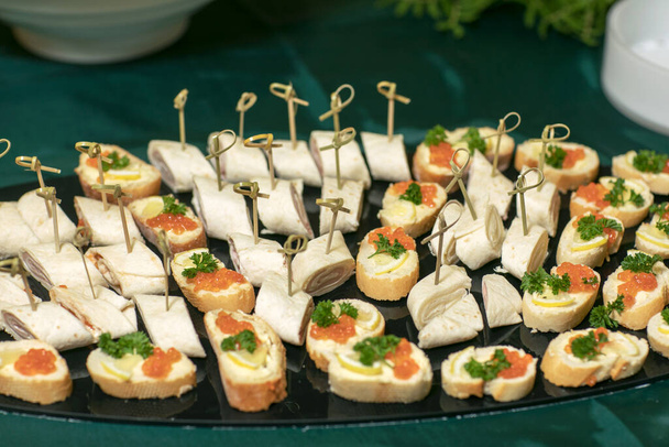 Роллы тонких блинчиков с копченым лососином, сливочным сыром, луком и салатом
. - Фото, изображение
