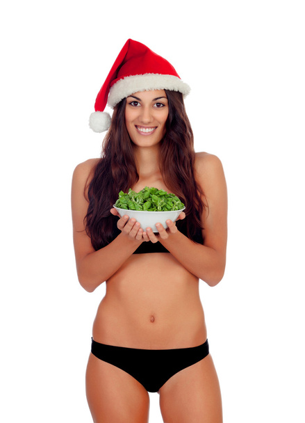 Girl in black underwear and a Santa hat and a salad - Foto, imagen
