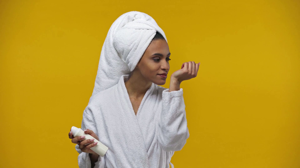 africano americano ragazza spruzzando deodorante isolato su giallo
  - Filmati, video