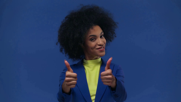 afroamericana chica mostrando pulgares arriba aislado en azul
 - Metraje, vídeo