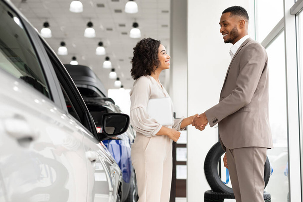 Afro Businessman Handshaking With Manager Girl Standing In Dealership Shop - Foto, immagini