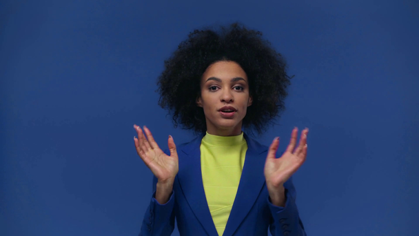 gelukkig Afrikaans amerikaans meisje praten geïsoleerd op blauw - Video