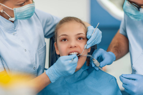 Dentist examining a patient's teeth in dentist office.People,stomatology and health care concept. - Photo, Image