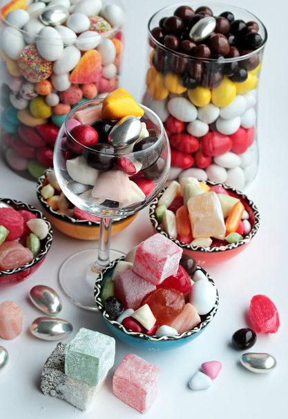 Colorful traditional candies, chocolates and Turkish delights in glass bowls on white background.Feast concept - Фото, зображення