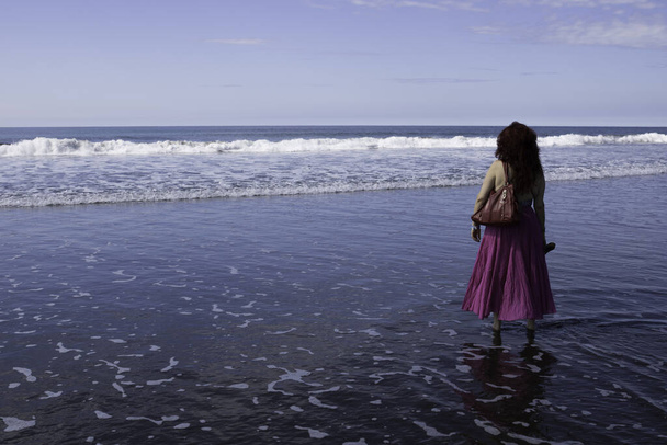 Mujer camina por la playa durante el día. - Foto, Imagen