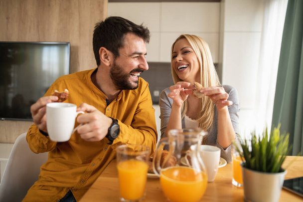Доброго ранку. Щаслива пара насолоджується сніданком вдома. Люди, любов, їжа та концепція щастя
. - Фото, зображення