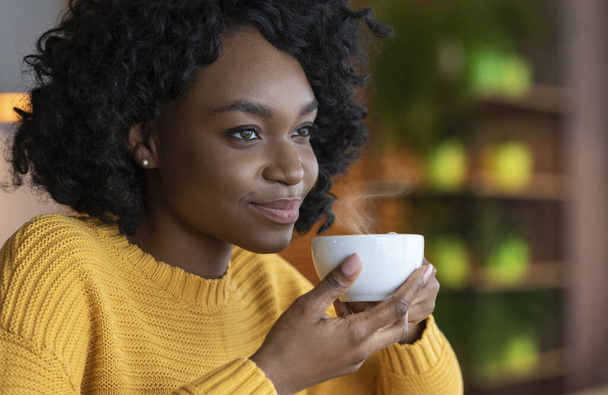 Közelkép portré afro nő élvezi egy csésze kávét - Fotó, kép