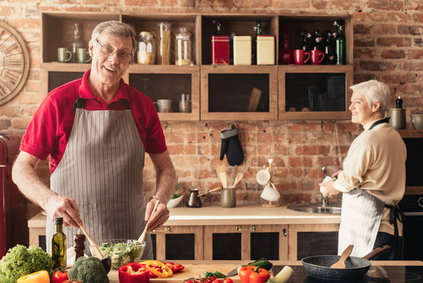 健康的な食べ物を準備する高齢者のカップル,一緒に台所で時間を過ごす - 写真・画像