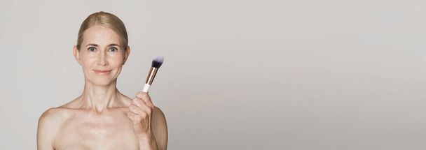 Beautiful caucasian middle aged woman holding brush - 写真・画像