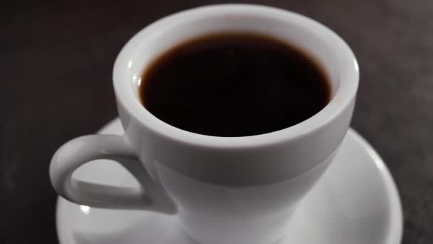 Капля медленно падает в кофе в чашке - Кадры, видео