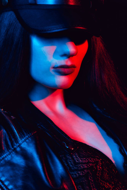 stylish Portrait of a young girl in a leather jacket and cap in a black bra - Photo, Image
