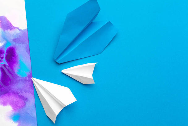 avião de papel branco em um fundo de papel de bloco de cor - Foto, Imagem