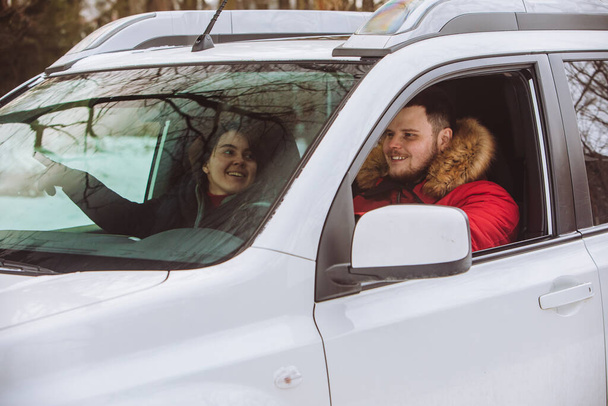 man and woman inside car in winter clothes. road trip - Photo, Image