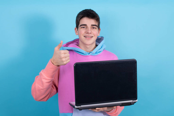 young teenage student with personal computer isolated on color background - Photo, Image