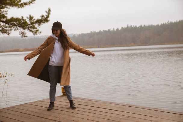 осінній сезон озера жінка в пальто на дерев'яному пірсі осінь
 - Фото, зображення