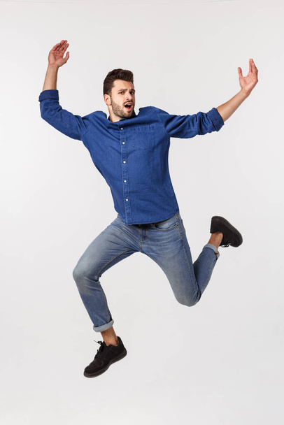 An attractive athletic businessman jumping up against white background - Fotoğraf, Görsel