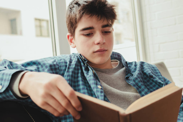 young teenage boy reading or studying at home - Foto, imagen