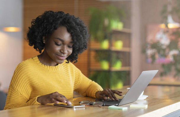Pozytywne afro businesswoman pracy online i korzystania z telefonu komórkowego - Zdjęcie, obraz