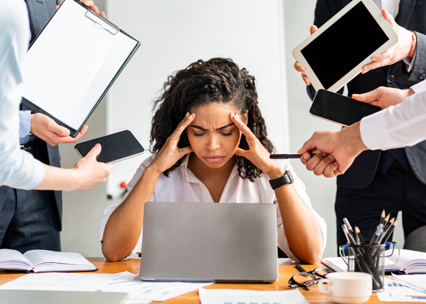 Наголошена бізнес-леді в ноутбуці торкаючись голови сидячи в сучасному офісі
 - Фото, зображення