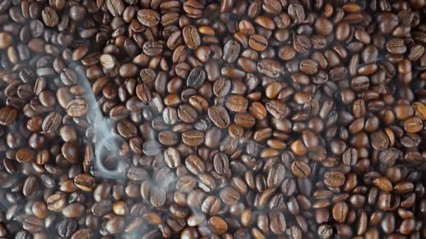 Roasted coffee beans with smoke in a pan - Footage, Video