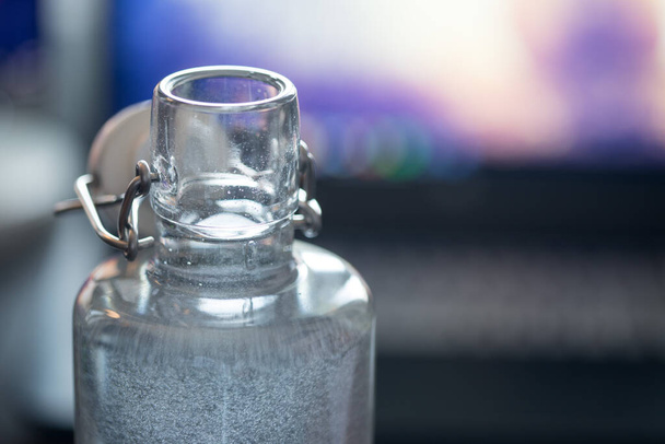 Close up of glass bottle in the office, drinking - Φωτογραφία, εικόνα