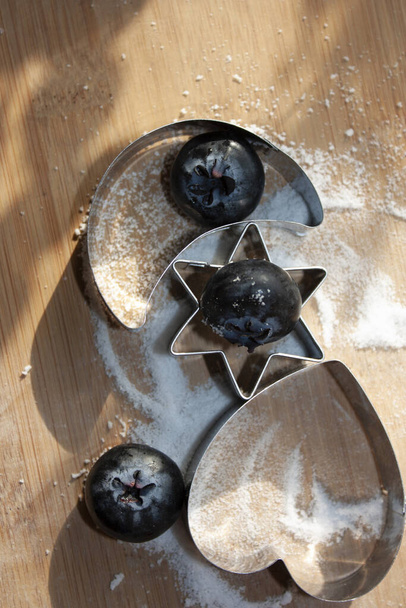 Blueberries eaten between moon and heart star figures that pose on sugar-free sweet granules for desser - Photo, Image