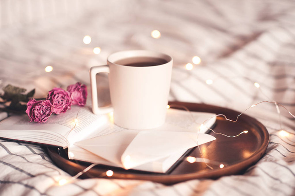 Çiçekli bir fincan kahve ve açık bir kitabın üzerinde duran bir mektup. İyi sabahlar. Sevgililer Günü.  - Fotoğraf, Görsel