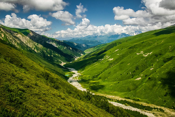 Stunning Adishi valley summer landscape seen from Chkhutnieri pass, Upper Svaneti, Georgia. Vibrant green slopes of Caucasus mountani range on a partially cloudy day. - Fotografie, Obrázek