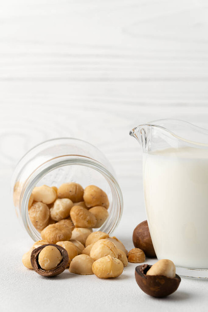 Milchfreie Milch. Macadamia-Nussmilch auf hellem Hintergrund. - Foto, Bild