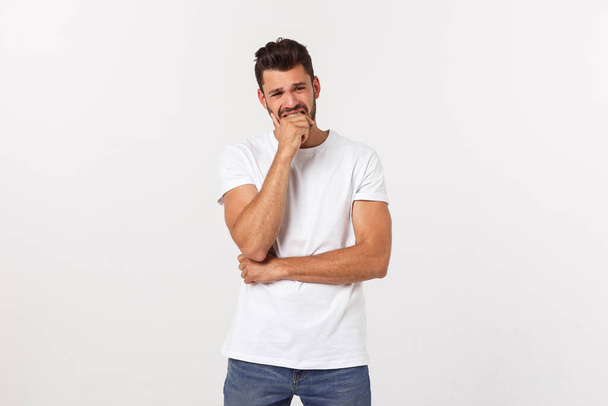 Close up portrait of disappointed stressed bearded young man in shirt over white background. - Foto, afbeelding