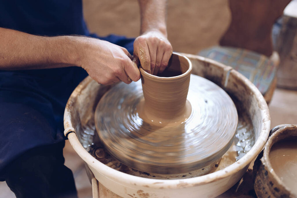 Поттер робить глиняну вазу на колесі гончаря. - Фото, зображення